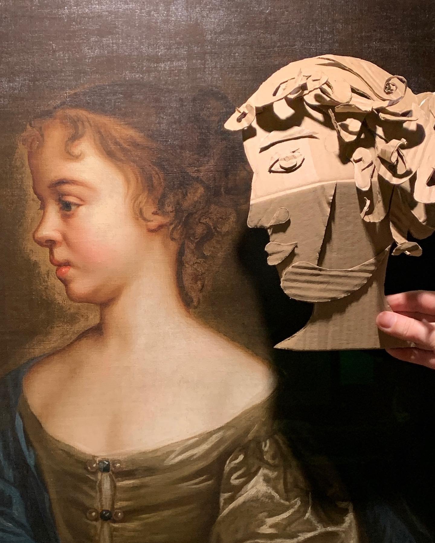 A hand-built cardboard sculpted head held alongside an 18th-century oil portrait — from a Lockarts heritage-sector workshop pairing contemporary making with historic collections.