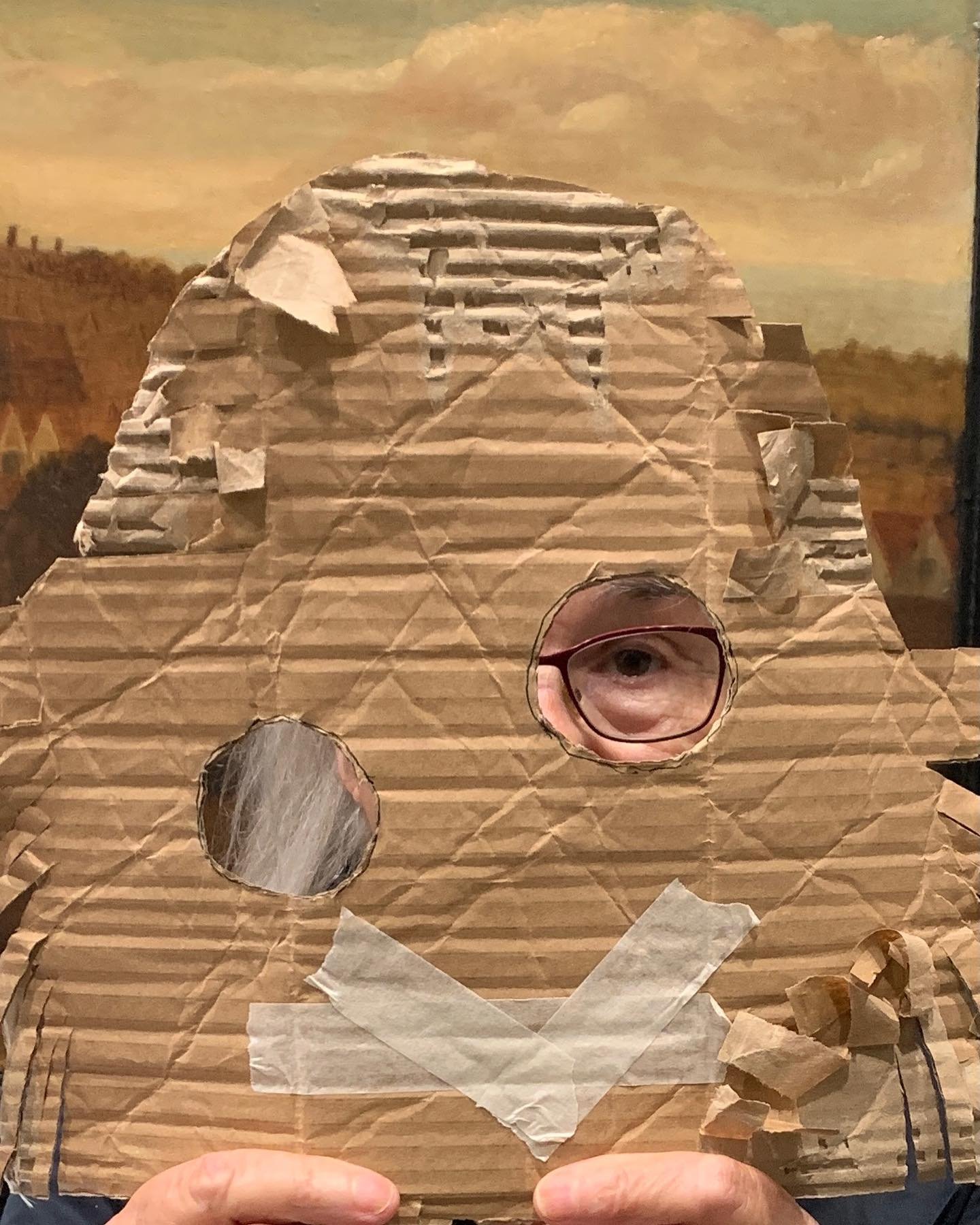 A participant holding a cardboard mask up against a historic Suffolk landscape painting during a Lockarts heritage-sector workshop.