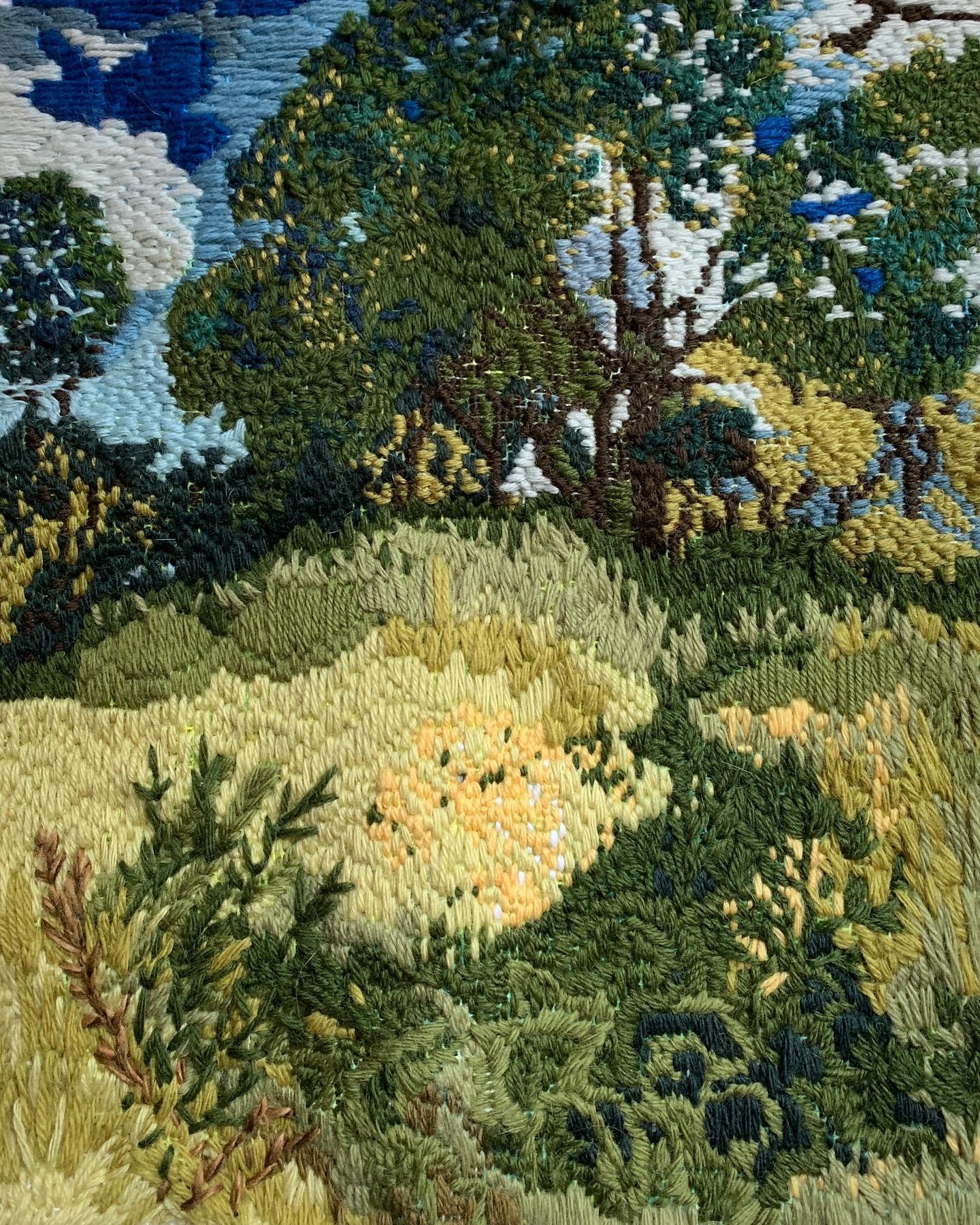 A close-up of a hand-embroidered landscape — trees, meadow and sky in wool — made during a Lockarts therapeutic arts session.